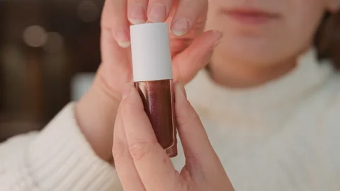 Hands twisting dropper cap from small cosmetic bottle before wrist application Stock Footage 343530756