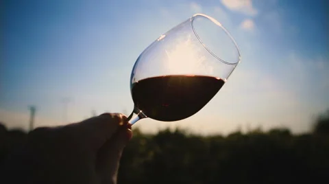 Hands twisting glass of wine  on background sun. Stockbeeldmateriaal 62261865