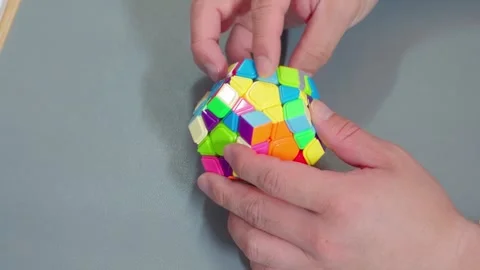 Hands Twisting Megaminx Speedcube On Grey Desk Video stock 339124074