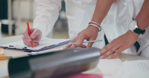 Hands of two doctors writes the diagnosis in medical documents Stock Footage 93820366