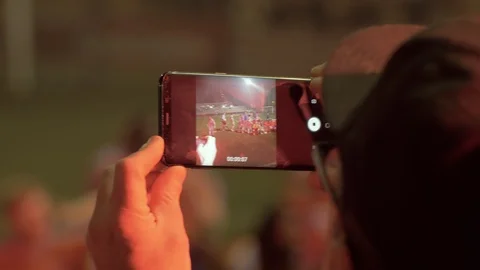 Hands of two men with a mobiles after a soccer match. Taking a picture with cell Stock Footage 118643178