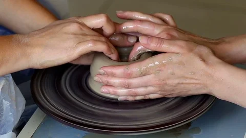 Hands of two people create pot, potter's wheel. Teaching pottery Stock Footage 78142682