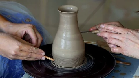 Hands of two people create pot, potter's wheel. Teaching pottery Stock Footage