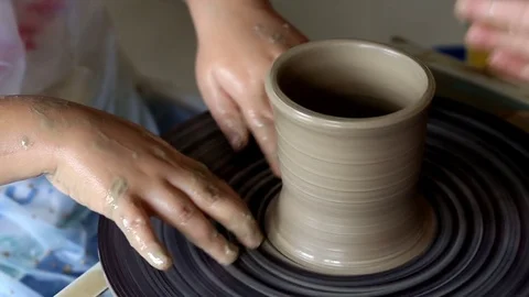 Hands of two people create pot, potter's wheel. Teaching pottery Stock Footage 78142815