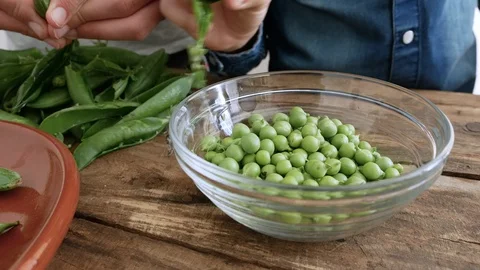 Hands of two people reoving peas from their pods Stock Footage 129710448