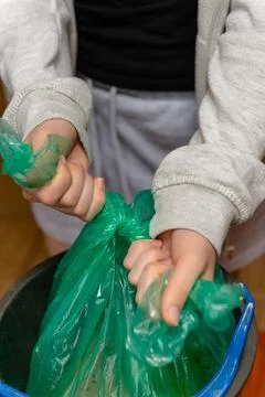 Hands tying green plastic garbage bag close up 写真素材