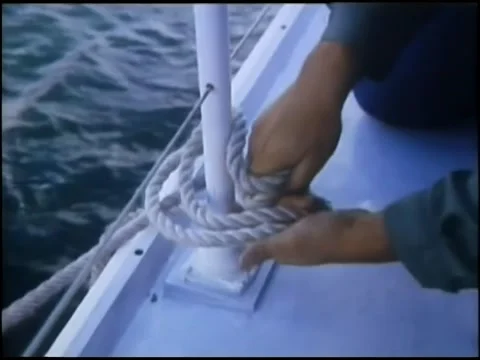 Hands tying rope to railing on ship Stock Footage 260249960
