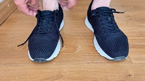 Hands Tying Running Sneakers Before Workout on Wooden Floor Indoors 库存影片 343067108