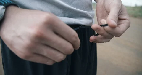 Hands tying waist string on black running shorts Video stock 98425987