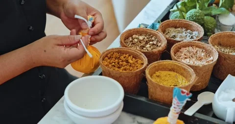 Hands tying yellow herbal compress ball in spa setting 動画素材 332774956