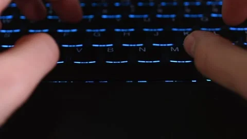 Hands typing on a back lit keyboard from an interesting viewpoint Stock Footage 145620640