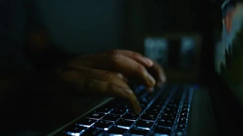 Hands typing on a backlit keyboard in a dark room Stock Footage 315982496