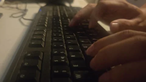 Hands typing on a black computer keyboard in a dark room 스톡 동영상 346546102