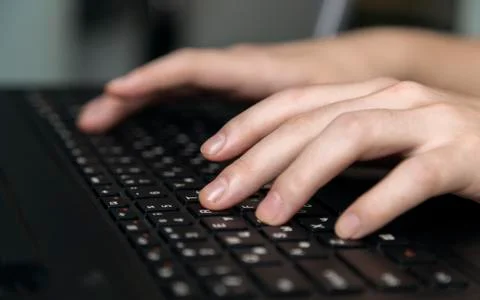 Hands typing on black keyboard, close up Stock Photos