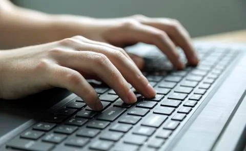 Hands typing on black keyboard, close up Stock Photos