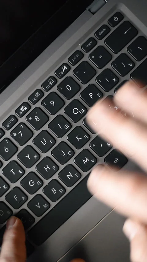 Hands typing on a black laptop keyboard, close-up view. Vertical video Stock Footage 325705045