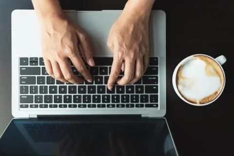 Hands typing a button on the laptop, top view Stock Photos