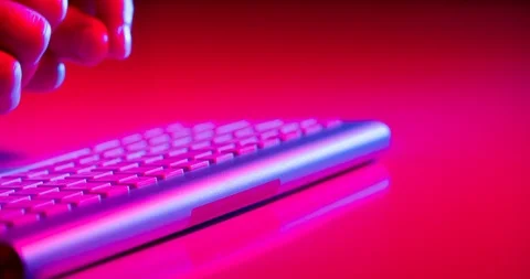 Hands typing on computer bluetooth keyboard with some red light of office work 库存影片 87459091