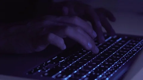 Hands typing on computer keyboard in darkness Stock Footage 81054594