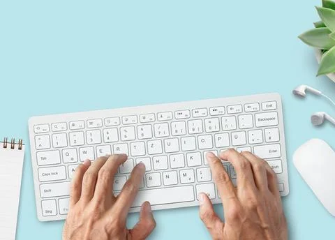 Hands typing on computer keyboard over white office desk table with cup of .. Stock Photos