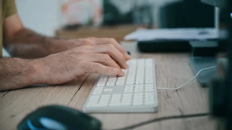 Hands typing on computer keyboard at wooden desk — office work and remote Stock Footage 333719134