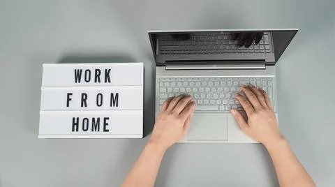Hands is typing on computer laptop or notebook on grey background.Studio shot Stock Photos
