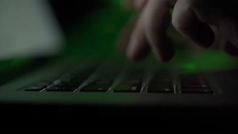 Hands typing in the dark with colored lights on a laptop keyboard. Shaky camera Stock Footage 194551839