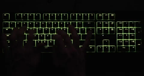 Hands typing in the dark on illuminated keyboard closeup Stock Footage 148096388