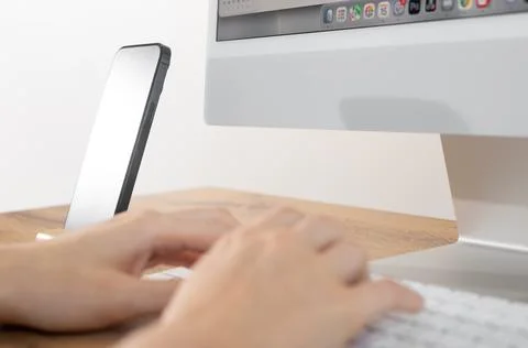 Hands typing on desktop keyboard close up at modern organized workspace. Pe.. Stock-Fotos