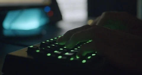 Hands Typing on Gaming Keyboard Glowing Green in Dark Room Stock Footage 115582505