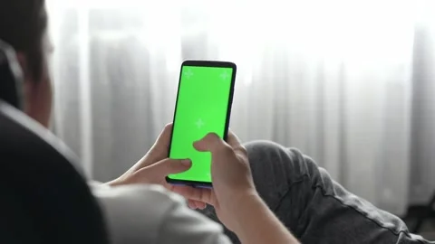 Hands typing on green screen phone at home Stock Footage 193968797
