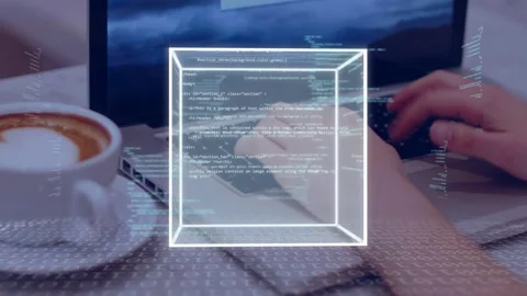 Hands typing initiating wireframe cube forming and rotating over laptop, coffee Stock Footage 335235099