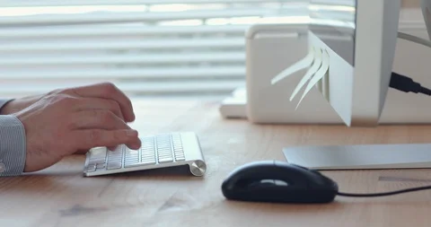 Hands typing on keyboard in bright modern office workplace Stock Footage 123947040