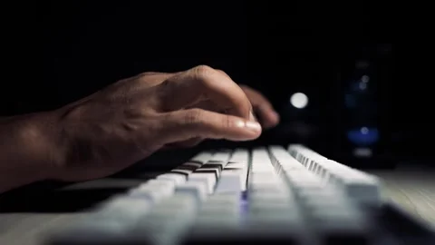 Hands typing on keyboard in dark room, Close-up of hands typing on a white .. 库存影片 334285684