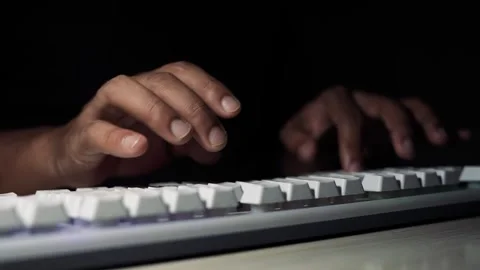 Hands typing on keyboard in dark workspace, Close-up of hands typing on a w.. Stock Footage 334285736
