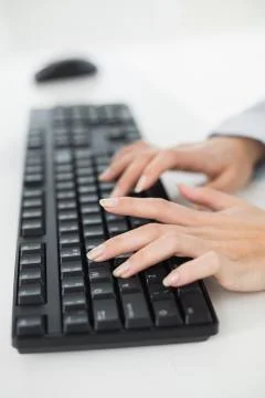 Hands typing on a keyboard in an office Stock Photos