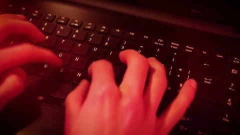 Hands typing on keyboard with red light 動画素材 80924572