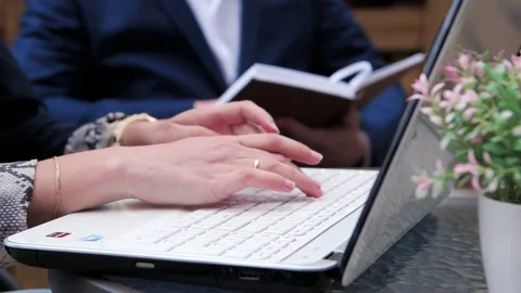 Hands typing on the keyboard in a summer cafe Видео 75475295