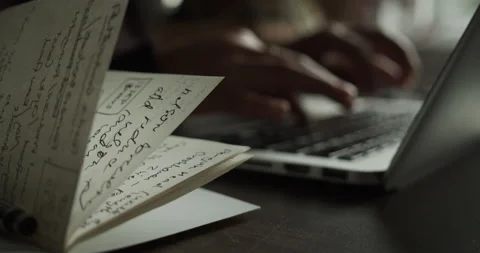 Hands typing on a keyoboard next to workbook Video stock 136761840