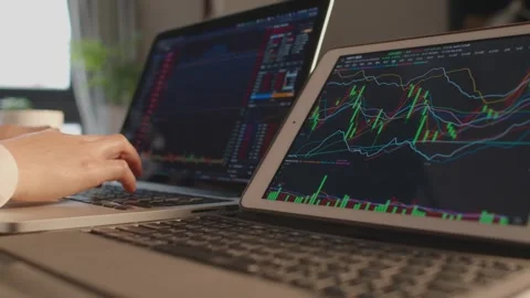 Hands Typing on Laptop Analyzing Stock Market Charts in Office 動画素材 336552520