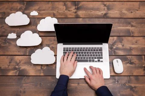 Hands typing on laptop with cloud storage concept Stock Photos