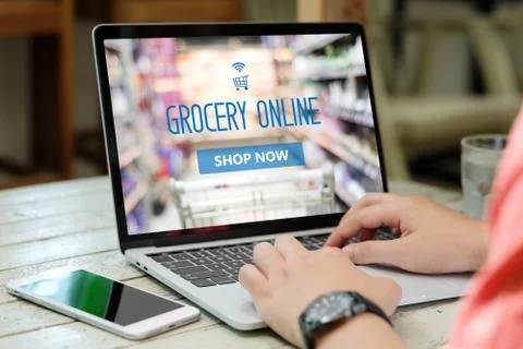 Hands typing laptop computer with grocery shopping online on screen backgroun Stock Photos
