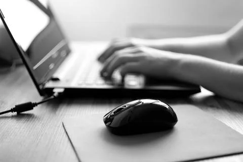 Hands typing on laptop computer keyboard, black and white Stock Photos