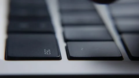 Hands typing on a laptop keyboard and pressing the Esc key during computer work Stockbeeldmateriaal 332789107