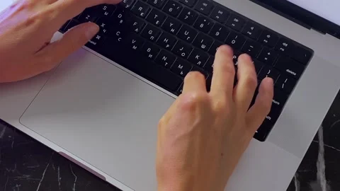 Hands typing on laptop keyboard, close-up top view at desk Stock Footage 346743126