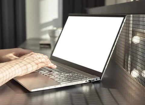 Hands typing on laptop keyboard with computer mockup screen Stock Photos