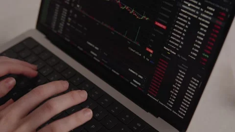 Hands typing on laptop keyboard with cryptocurrency trading platform open Stock Footage 317952425