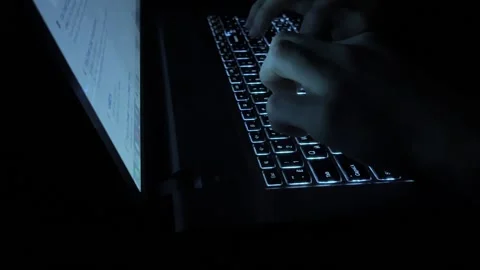 Hands typing on a laptop keyboard in the dark. Stock Footage 165550479