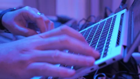 Hands typing on laptop keyboard in neon light Stock Footage 345115474
