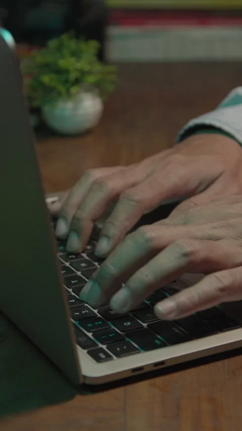 Hands typing on a laptop keyboard at night on a desk Stock Footage 333958465